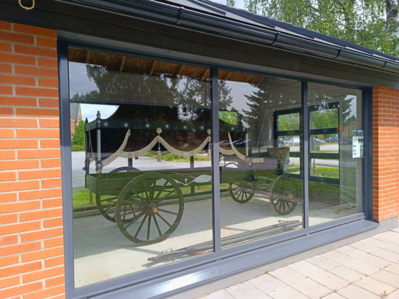 The hearse is displayed in a glass case.