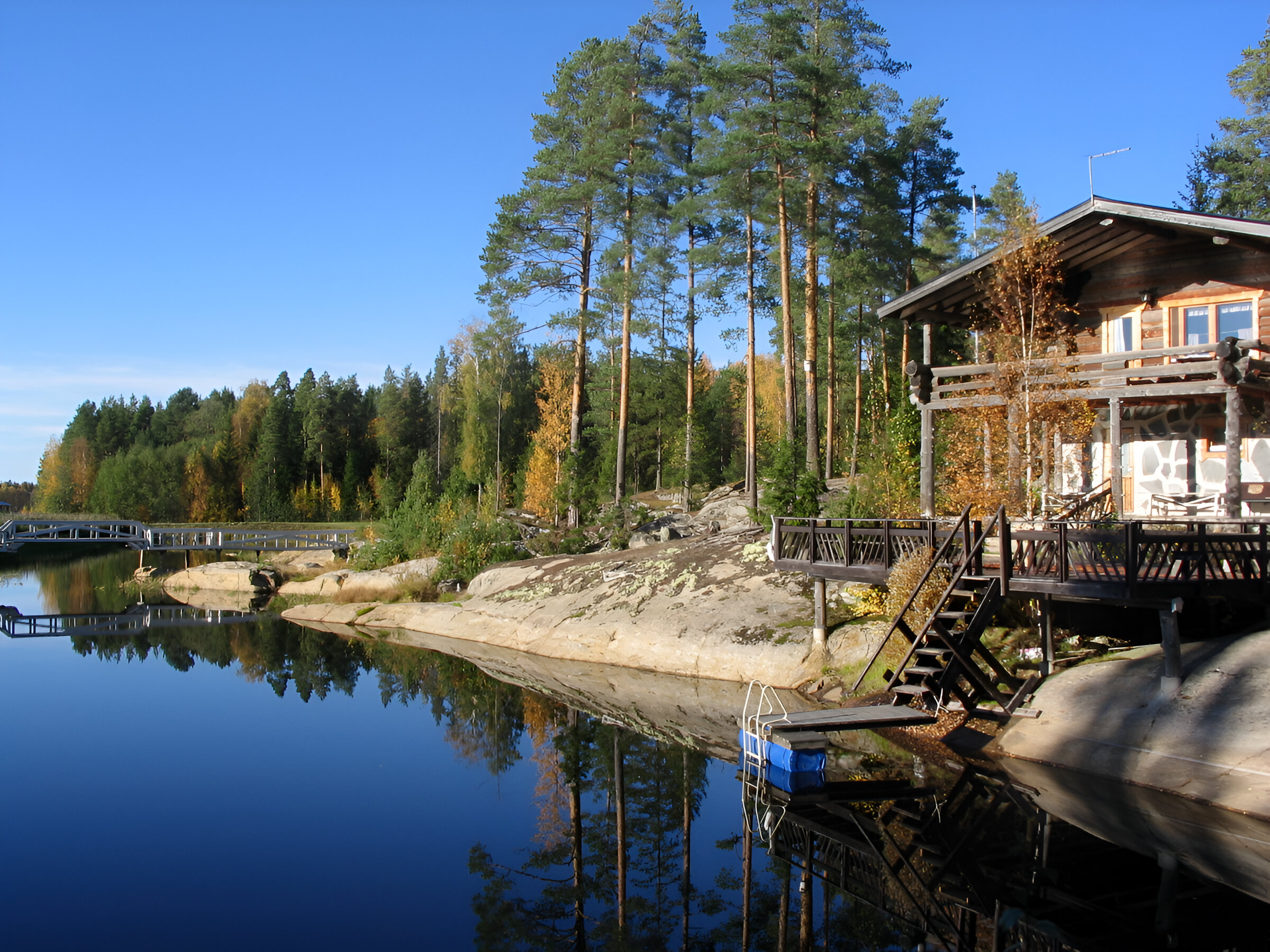 Mökki ja järvi maisemaa.